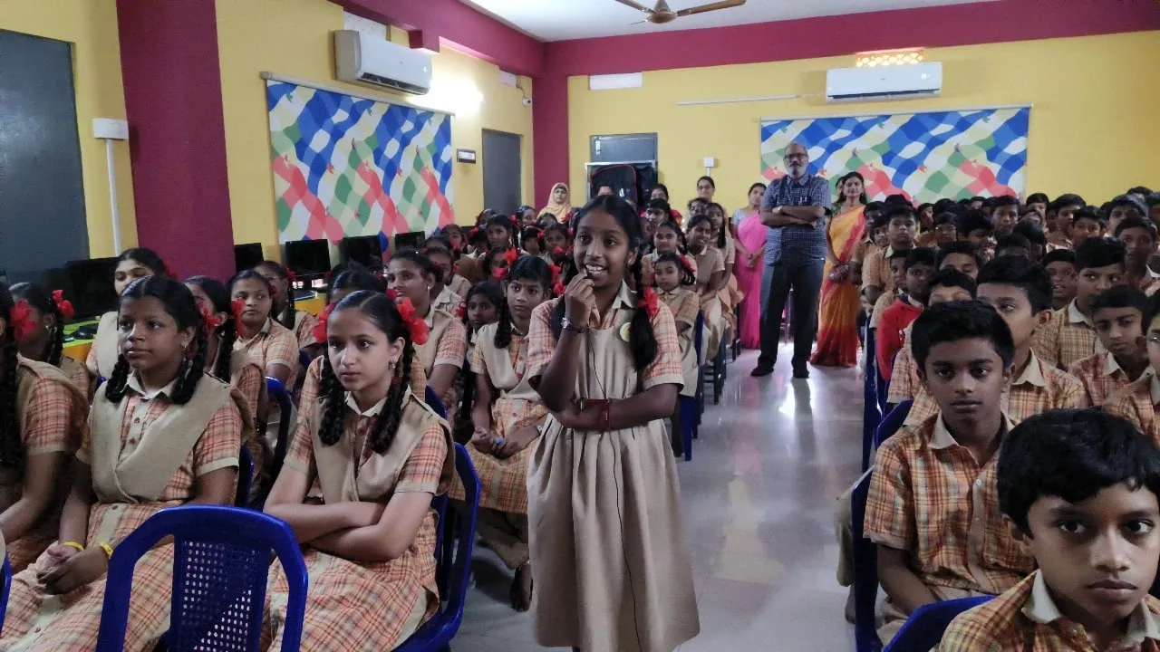 Science exhibition — students presenting models in a classroom.